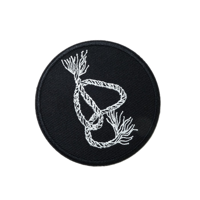 circular embroidered patch, white outlines of a snaking piece of braided rope with frayed ends on black background