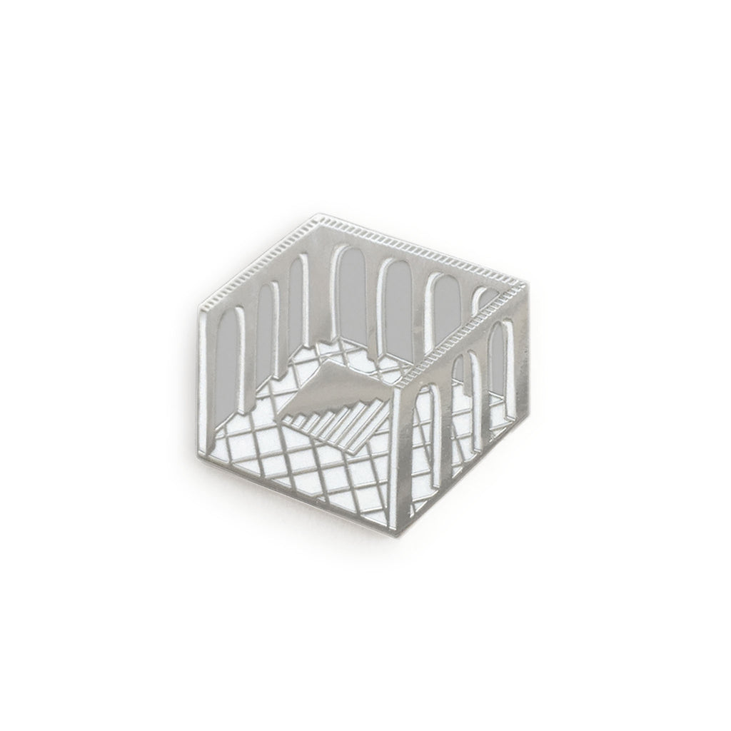 a highly reflective hard enamel pin, a diamond shaped cross-section of a room with no ceiling, arches cut into the walls, tiled floor, and a hole in the floor containing steps leading below, silver outlines, grey negative space for the arches, white tiles and highlights